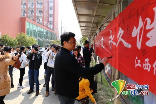 学院党委书记等领导带头在横幅上签字。中国青年网通讯员 赖鹏 摄
